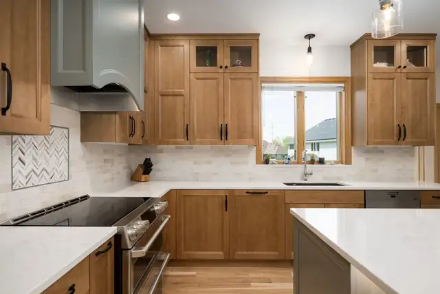 South Lake Owasso kitchen with stained wood cabinets, glass-front uppers and a herringbone tile accent