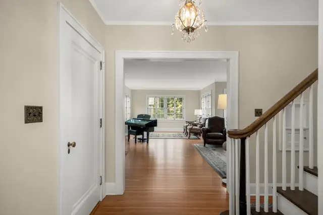Montcalm whole home remodel in St. Paul showing a refinished front hall, white staircase and view into the living room